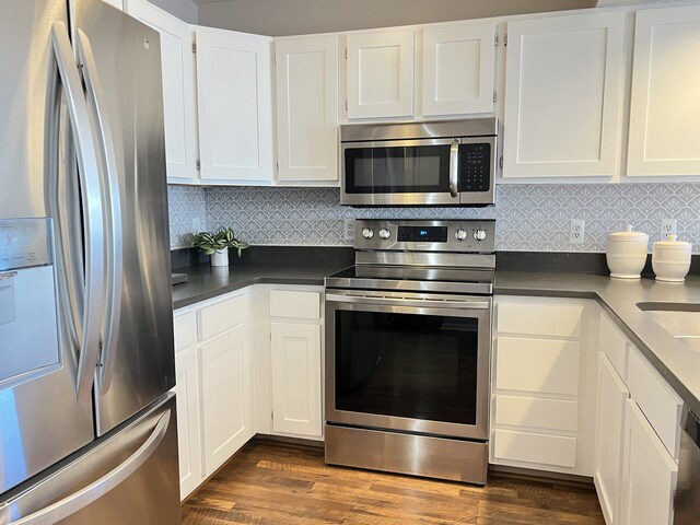 kitchen featuring tasteful backsplash, appliances with stainless steel finishes, dark hardwood / wood-style floors, and white cabinets