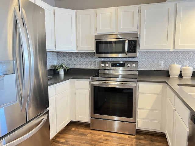 kitchen featuring stainless steel appliances, white cabinetry, and dark hardwood / wood-style floors