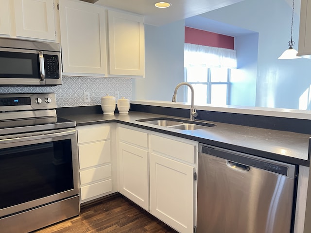 kitchen with sink, white cabinetry, hanging light fixtures, stainless steel appliances, and backsplash