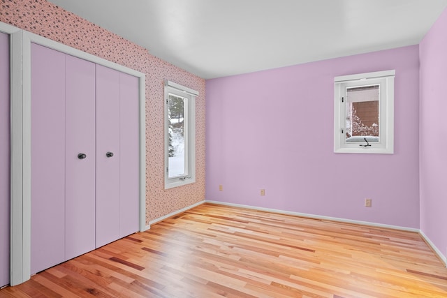 unfurnished bedroom with a closet and light hardwood / wood-style flooring