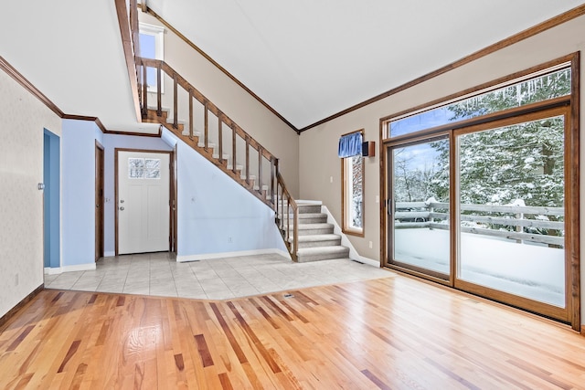 foyer entrance featuring light hardwood / wood-style floors, high vaulted ceiling, and ornamental molding