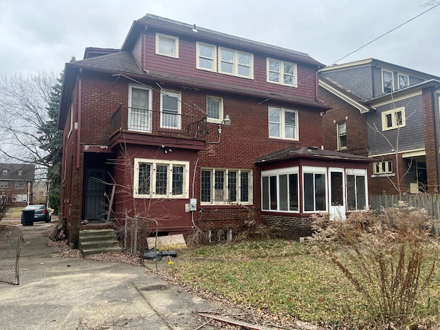 back of house featuring a sunroom and a balcony