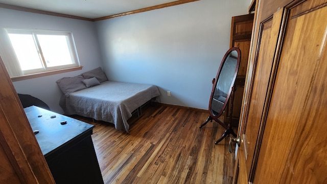 bedroom with dark hardwood / wood-style floors and ornamental molding