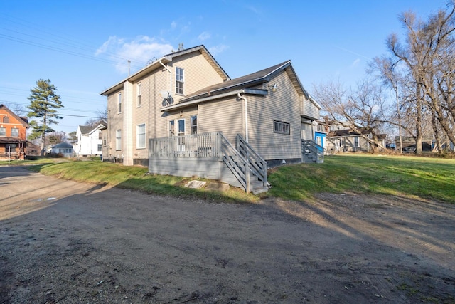 view of side of property featuring a lawn and a wooden deck