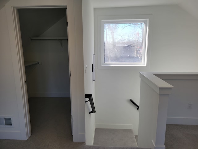 stairway with visible vents, lofted ceiling, baseboards, and carpet flooring