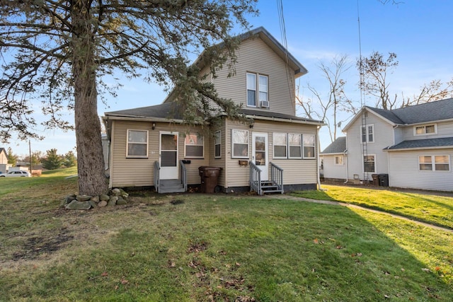 rear view of property featuring a lawn