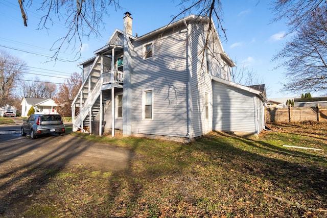 view of side of property featuring a balcony and a yard