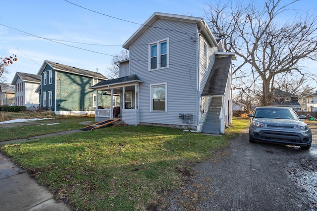 view of property with a front yard and covered porch