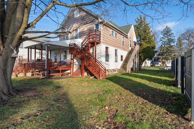 back of property featuring a lawn and a wooden deck