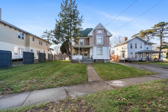 view of front of home featuring covered porch and a front lawn