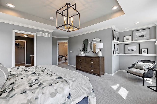 carpeted bedroom with an inviting chandelier, a walk in closet, crown molding, and a closet