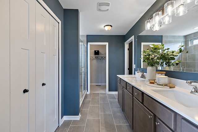 bathroom with tile patterned flooring, vanity, and a shower with shower door