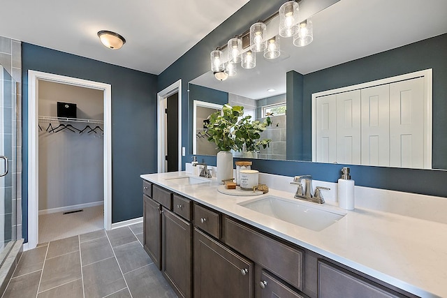 bathroom featuring tile patterned floors, vanity, and a shower with shower door