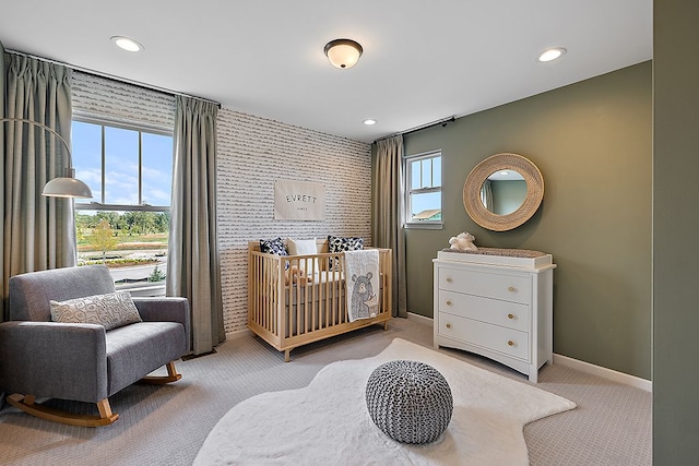 bedroom with a crib and light colored carpet