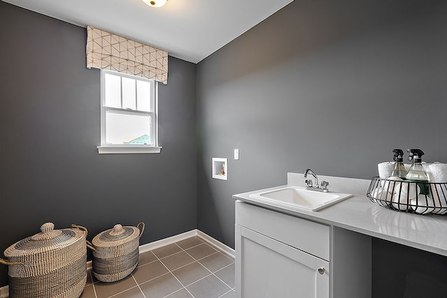 washroom with washer hookup, light tile patterned flooring, cabinets, and sink