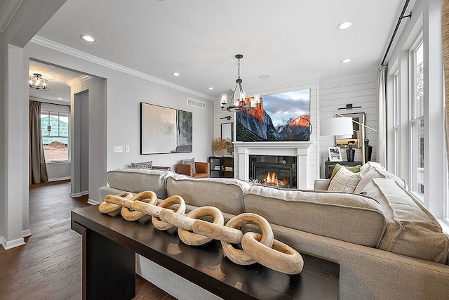 living room featuring a chandelier, dark hardwood / wood-style floors, and ornamental molding