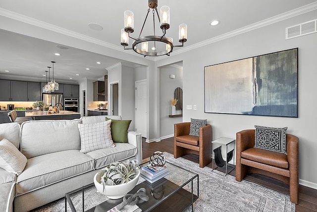 living room with hardwood / wood-style floors, a notable chandelier, and crown molding