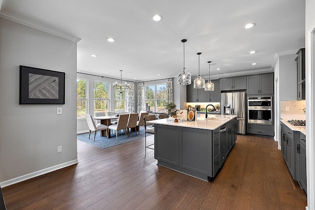 kitchen with stainless steel appliances, crown molding, an island with sink, pendant lighting, and gray cabinets