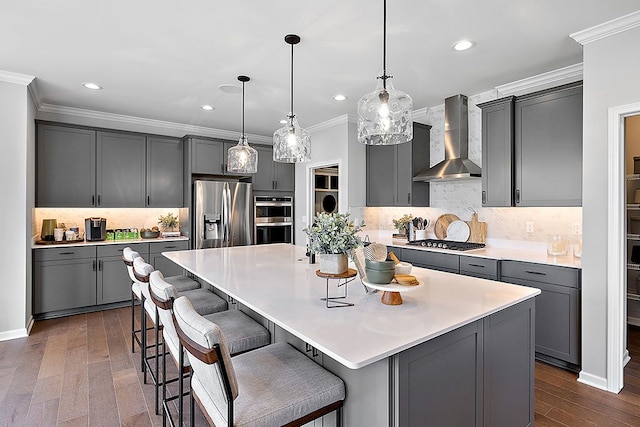 kitchen with gray cabinetry, wall chimney exhaust hood, and stainless steel appliances