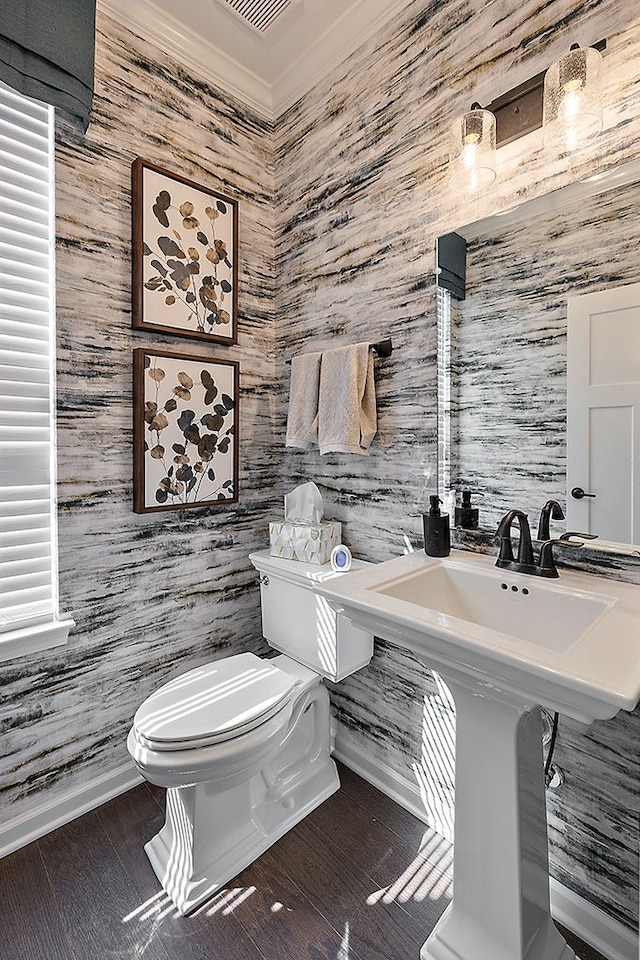 bathroom with hardwood / wood-style flooring, toilet, ornamental molding, and tile walls