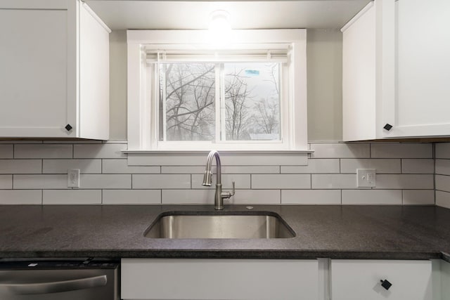 kitchen featuring tasteful backsplash, dishwasher, sink, and white cabinets