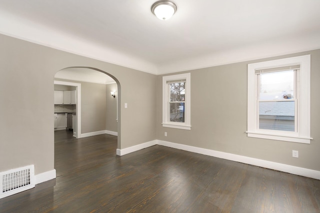 unfurnished room featuring plenty of natural light and dark wood-type flooring