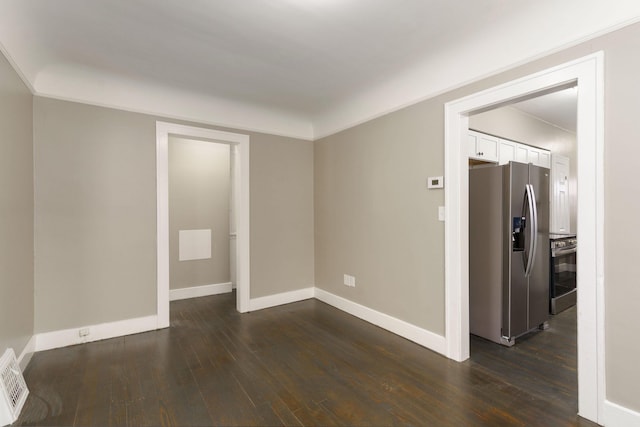 spare room with dark hardwood / wood-style flooring and crown molding