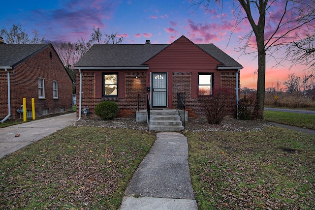 bungalow-style home with a yard