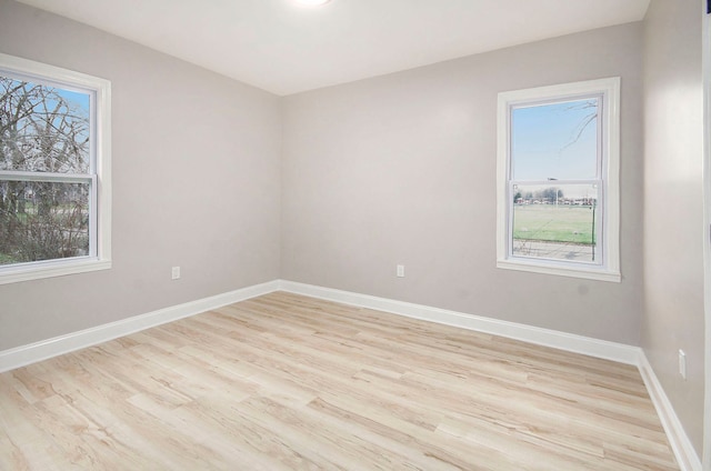 spare room with light hardwood / wood-style floors and plenty of natural light