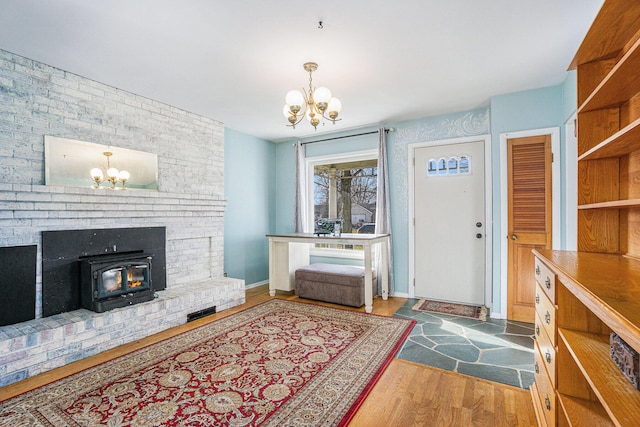 entrance foyer with a notable chandelier, dark hardwood / wood-style floors, and a wood stove