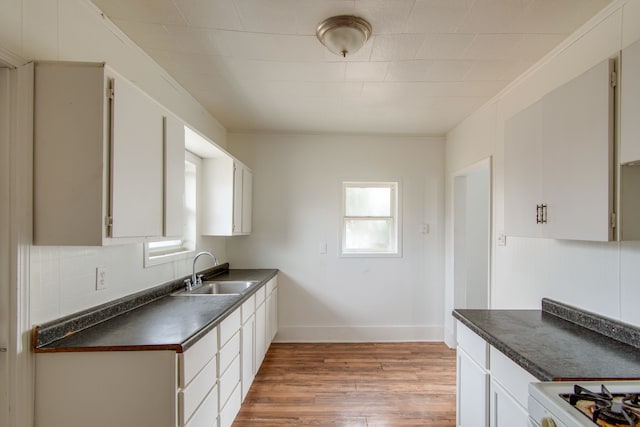 kitchen featuring backsplash, white range, sink, light wood-type flooring, and white cabinetry