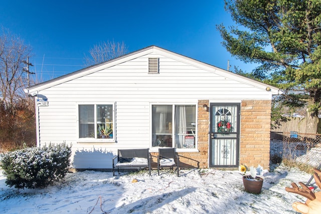 view of snow covered back of property