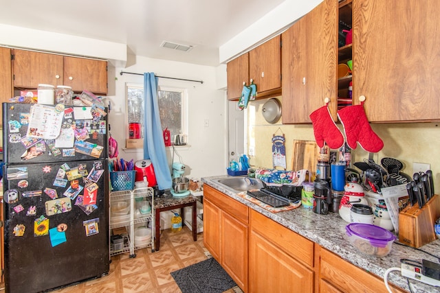 kitchen featuring refrigerator and sink