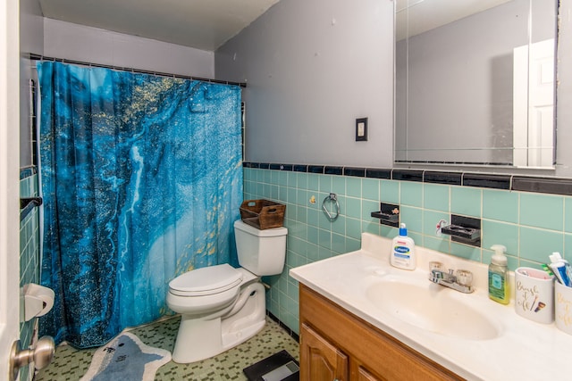 bathroom with curtained shower, tile patterned flooring, toilet, vanity, and tile walls