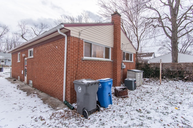 snow covered property featuring central air condition unit