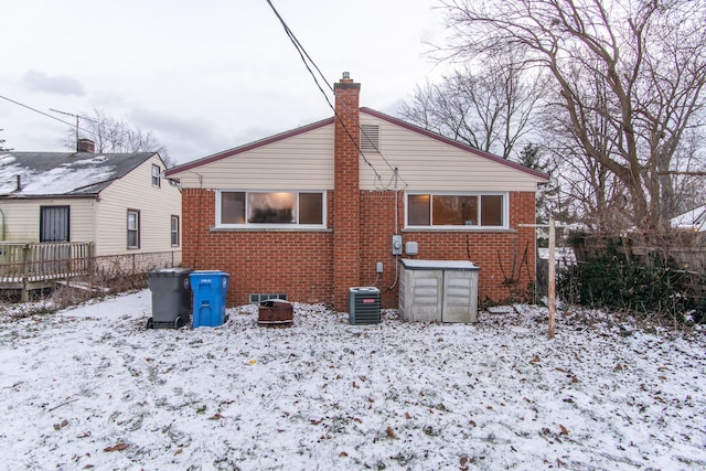 snow covered back of property with central air condition unit