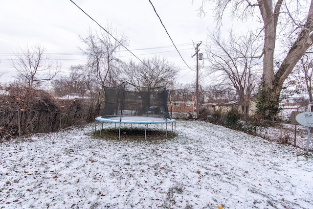 yard covered in snow with a trampoline