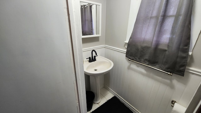 bathroom featuring tile patterned floors and wooden walls