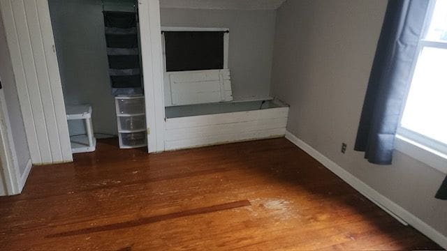 unfurnished bedroom with dark hardwood / wood-style flooring