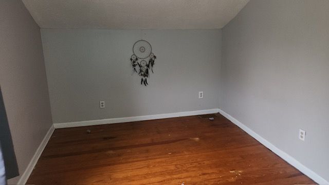 empty room featuring dark hardwood / wood-style flooring and vaulted ceiling