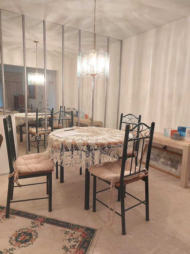 carpeted dining area featuring an inviting chandelier