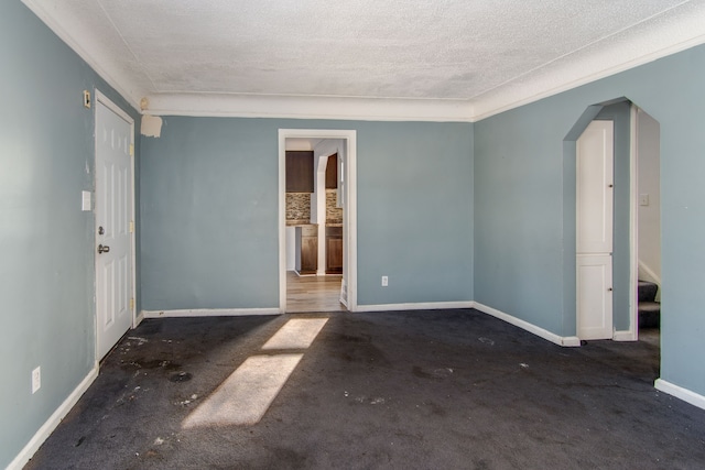 carpeted empty room featuring a textured ceiling