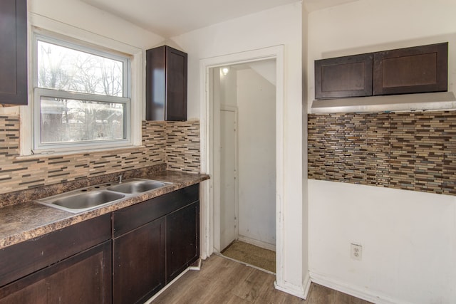 kitchen with sink, dark hardwood / wood-style flooring, dark brown cabinetry, and backsplash