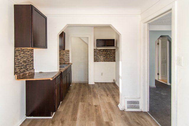 hallway featuring sink, light hardwood / wood-style floors, and ornamental molding