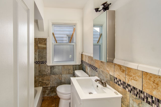 bathroom with vanity, toilet, tile walls, and a bathing tub