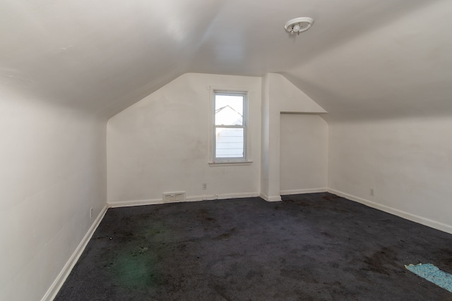 bonus room featuring dark carpet and lofted ceiling