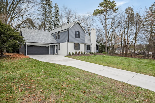 view of property with a garage and a front lawn