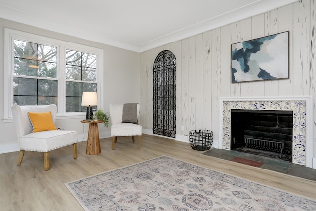 sitting room with hardwood / wood-style flooring and wood walls