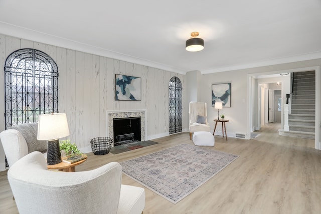 living room featuring wooden walls, ornamental molding, and hardwood / wood-style flooring