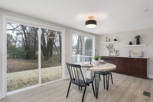 dining area with a wealth of natural light and light hardwood / wood-style flooring